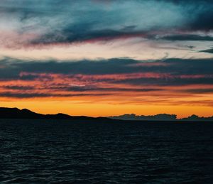 Scenic view of sea against dramatic sky during sunset