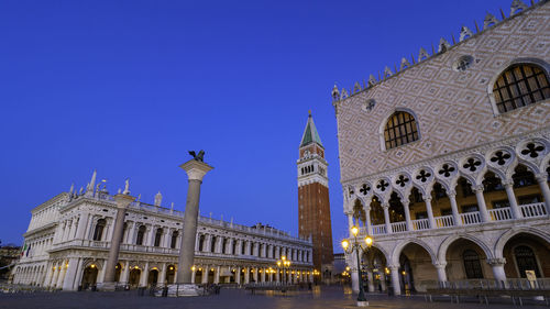 Low angle view of illuminated building against blue sky