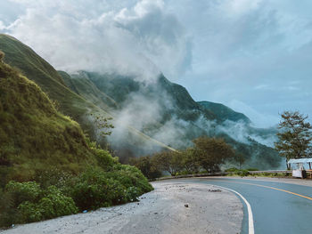 Road amidst trees against sky