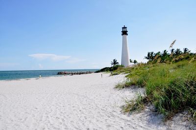 Lighthouse by sea against sky