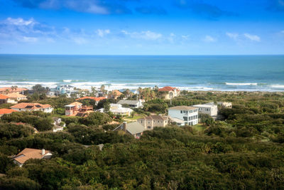 High angle view of buildings by sea against sky