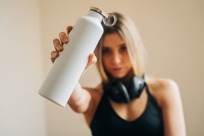 Midsection of woman holding glass bottle