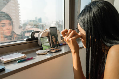 Young woman recording a make up tutorial