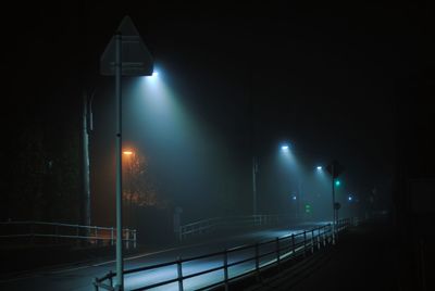 Illuminated street light on road at night