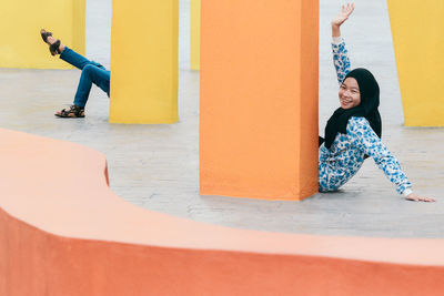 Friends sitting behind columns