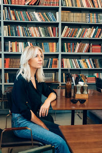 Young woman sitting on book at table