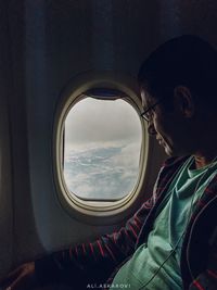 Portrait of man seen through airplane window