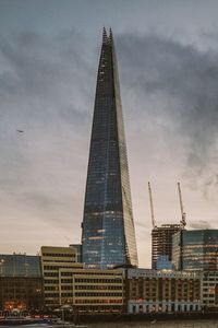 Low angle view of buildings against cloudy sky