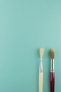 Close-up of paintbrushes over blue background