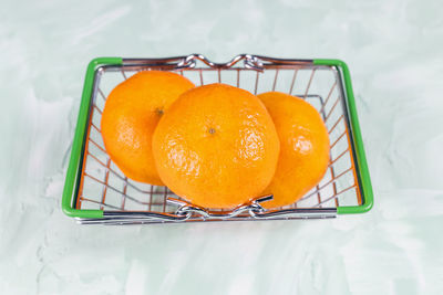 Colorful fresh orange mandarins in a small busket. market and shopping citrus fruit concept