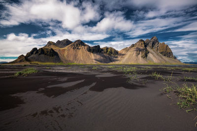 Scenic view of land and mountains against sky