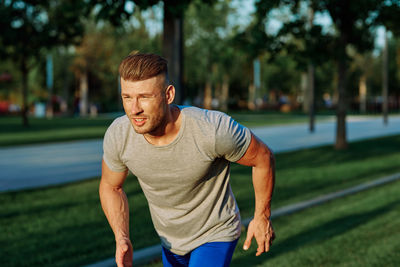 Portrait of young man exercising in park