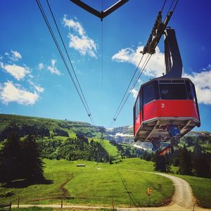 Low angle view of overhead cable car against sky