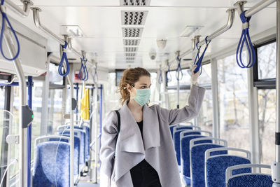 Full length of woman sitting in train