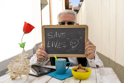 Man holding slate with text while sitting at table in restaurant