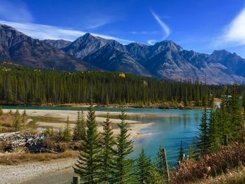 Scenic view of lake by mountains against blue sky