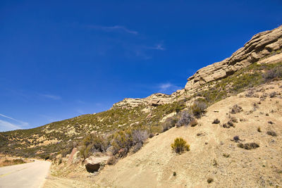 Low angle view of mountain against blue sky