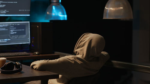 Rear view of woman using digital tablet at home