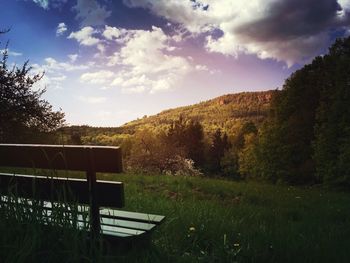 Scenic view of grassy field against cloudy sky