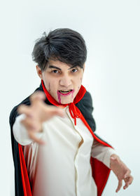 Portrait of young man standing against white background