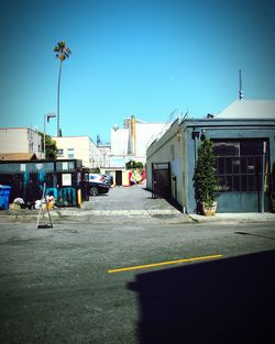 Man walking on road against buildings