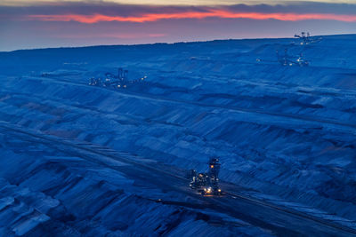 High angle view of illuminated coalmining dock against sky during sunset