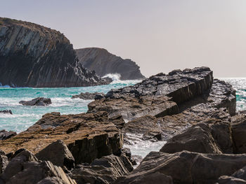 Rock formation on beach against clear sky