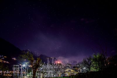 Low angle view of illuminated trees against sky at night