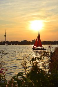 Sailboat sailing on sea against sky during sunset