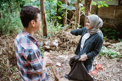 Side view of woman standing in forest