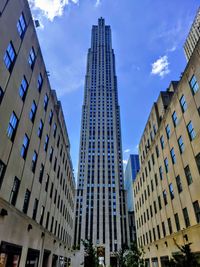 Low angle view of modern buildings against blue sky