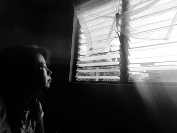 Portrait of woman looking through window