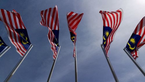 Low angle view of malaysian flags on poles