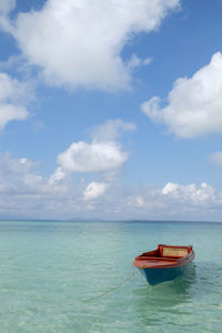 Boat moored in sea against sky