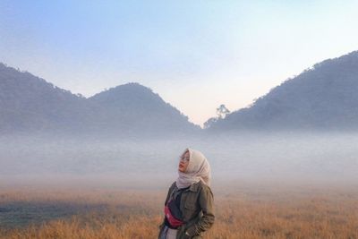 Woman on field against mountain range