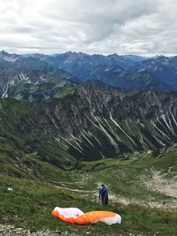 Hiker on field against mountains