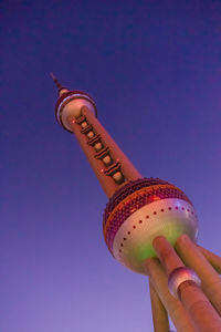 Low angle view of person holding ice cream against blue sky