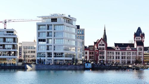 Buildings in city against clear sky