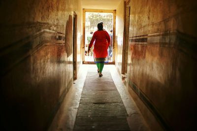 Rear view of man walking on road