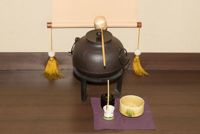 Close-up of japanese tea maker on floor against wall
