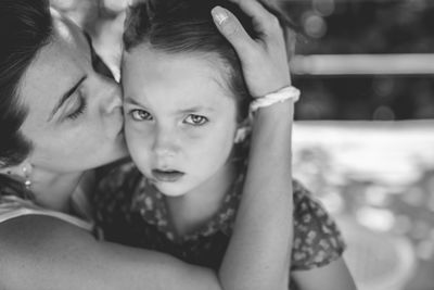 Close-up of mother kissing daughter while embracing