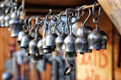 Close-up of bells hanging from metal rod at market