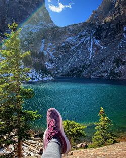 Maroon shoes with blue-green water of emerald lake in the background