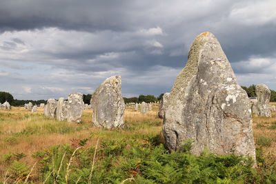 Panoramic view of rock formation on field against sky