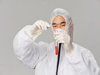 Doctor holding dentures against white background