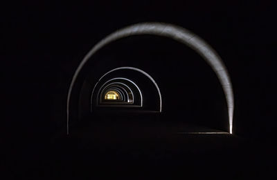 Low angle view of illuminated light against black background