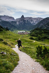 Rear view of man jumping while hiking on mountain