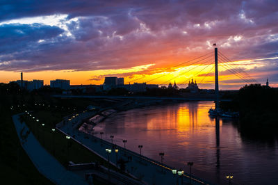 Silhouette bridge over river against sky during sunset