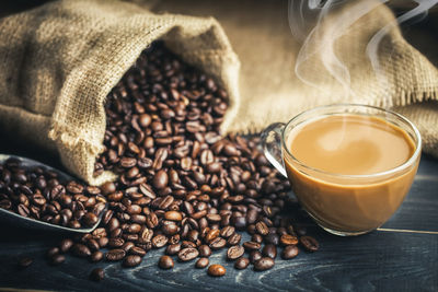 Close-up of coffee cup and beans on table