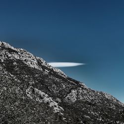 Low angle view of mountain against clear blue sky